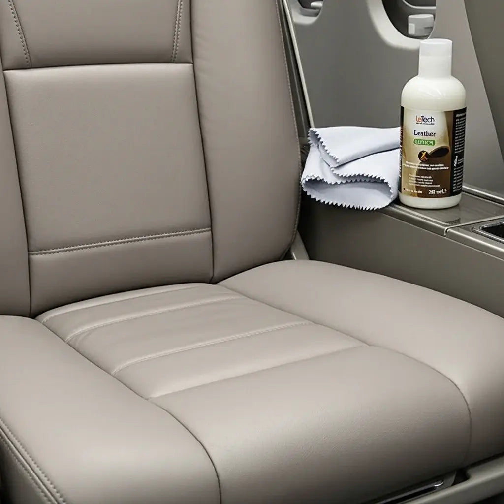 Car interior with beige leather seat, bottle of leather conditioner, and cloth. LeTech leather repair